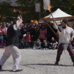 deux hommes jonglant avec des bâtons de feu